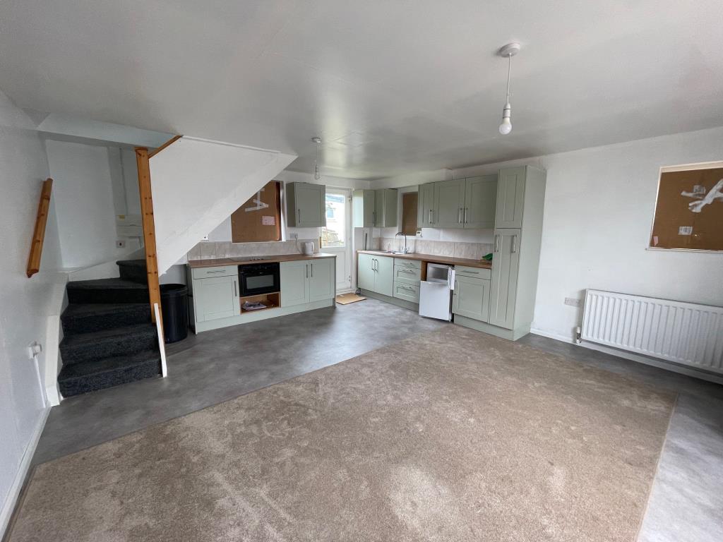 Lot: 101 - DETACHED BUILDING WITH POTENTIAL - Open plan room with kitchen area back door and stairs to upper level